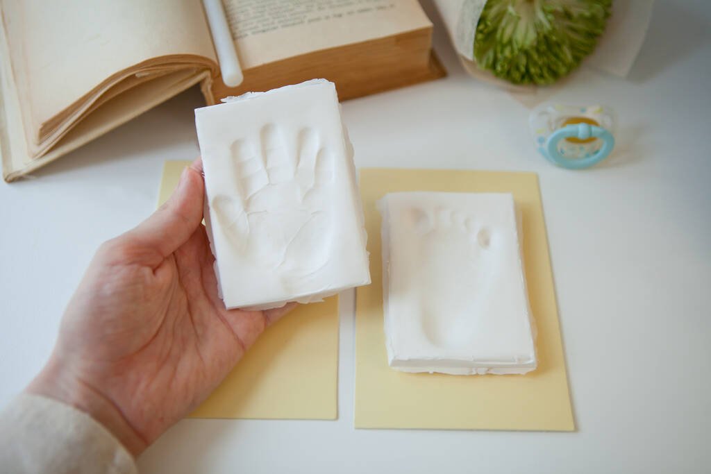 Baby footprint and handprint on clay mold plaque